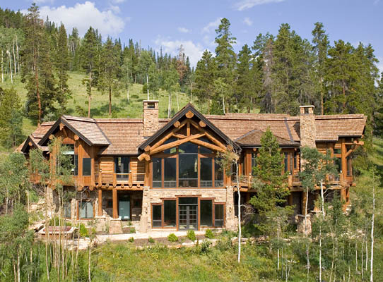 Large windows take in the mountain view of this hybrid log home