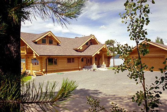 Cedar handcrafted log house with flared cedar butts and seperate garage